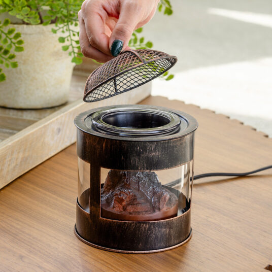 The Fire Pit Wax Warmer brings the cozy ambiance of a crackling fire into your home. The design mimics a rustic fire pit, featuring a mesh lid and the comforting glow of smoldering embers. Enjoy the essence of the outdoors year-round while filling your space with your favorite scents.